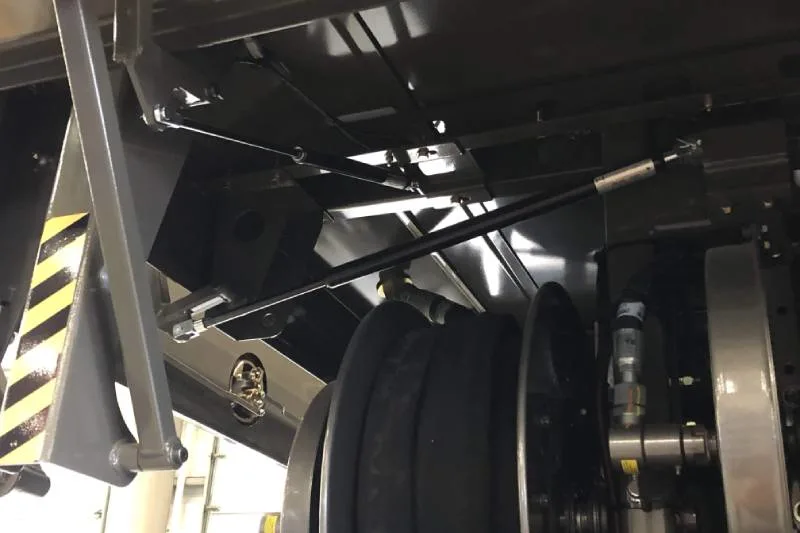 Gas compression spring fitted to a hinged industrial equipment lid